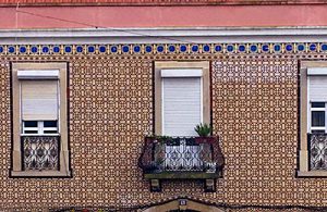 An intricately tiled wall with three windows.