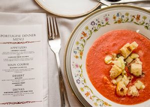 A menu next to a bowl of colorful soup.