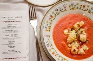 A menu next to a bowl of colorful soup.