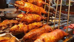 A batch of guinea pigs roasting on skewers.