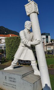 Statue of a man holding up a post
