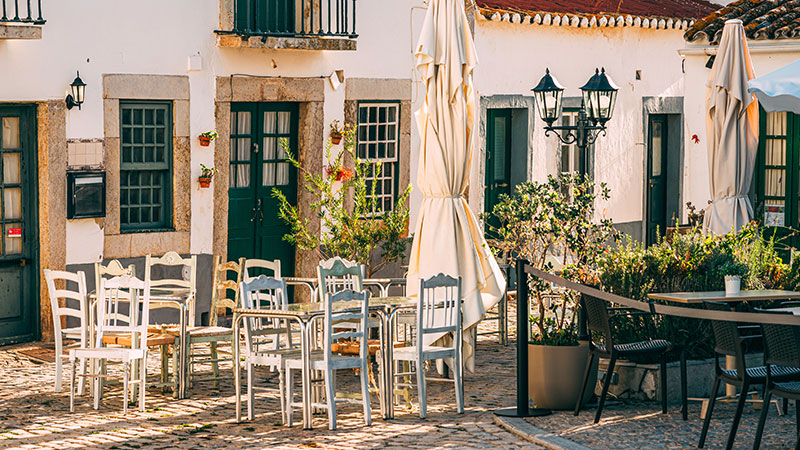 Outdoor seating on a cobblestone patio in Portugal