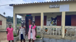 Three women posing in front of the Malanza Primary School.